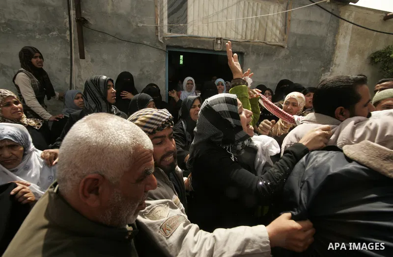 Palestinian relatives mourn on the body of Saleh Tarabin during his funeral in the southern Gaza Strip town of Rafah on April 8, 2011. The three were killed the day before in a series of more than a dozen Israeli air rai...