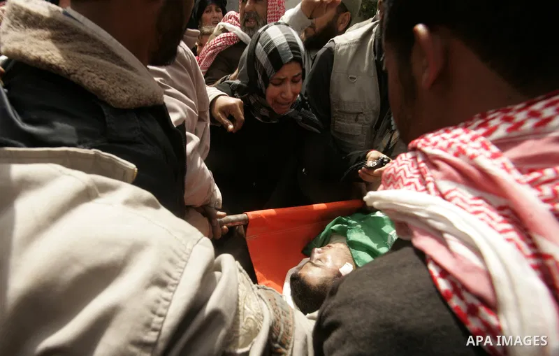 Palestinian relatives mourn on the body of Saleh Tarabin during his funeral in the southern Gaza Strip town of Rafah on April 8, 2011. The three were killed the day before in a series of more than a dozen Israeli air rai...