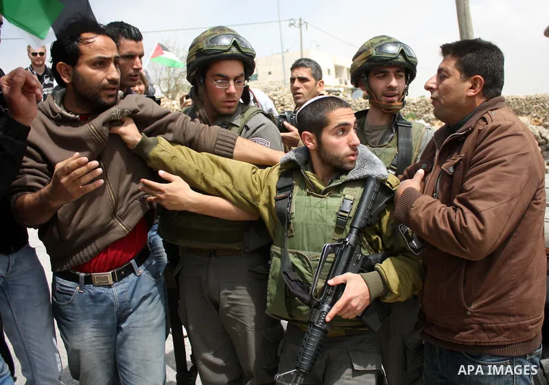 Protesters argue with an Israeli soldier during a demonstration against Israel's controversial separation barrier in the West Bank village of Maasarah, near the biblical town of Bethlehem on April 08, 2011.Israel says th...