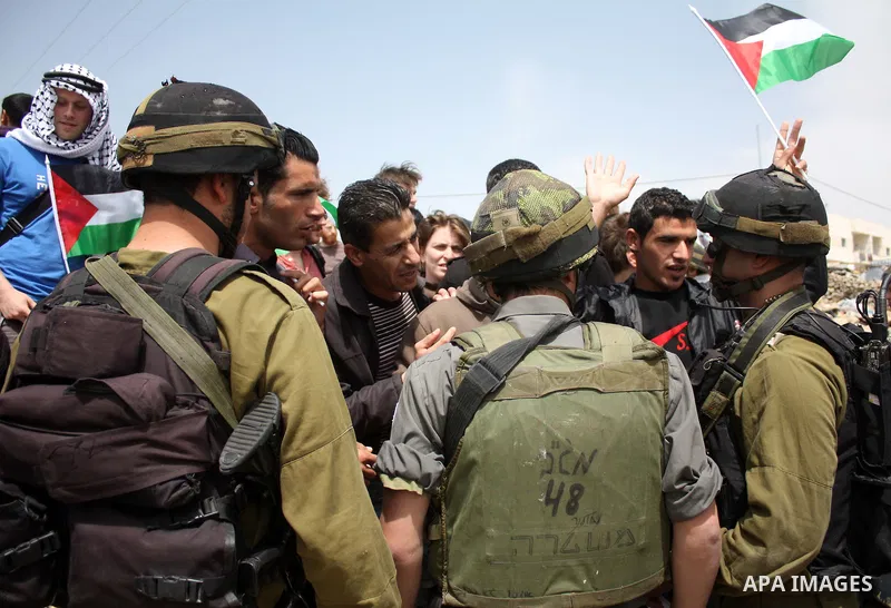 Protesters argue with an Israeli soldier during a demonstration against Israel's controversial separation barrier in the West Bank village of Maasarah, near the biblical town of Bethlehem on April 08, 2011.Israel says th...