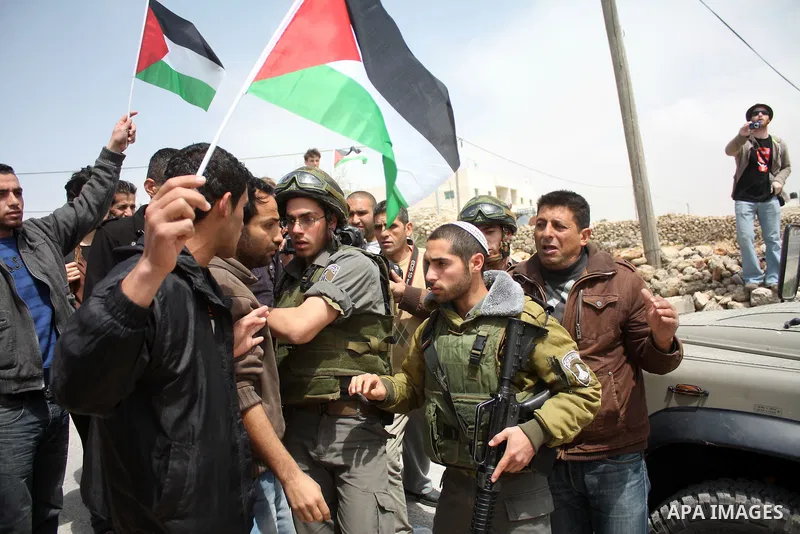 Protesters argue with an Israeli soldier during a demonstration against Israel's controversial separation barrier in the West Bank village of Maasarah, near the biblical town of Bethlehem on April 08, 2011.Israel says th...