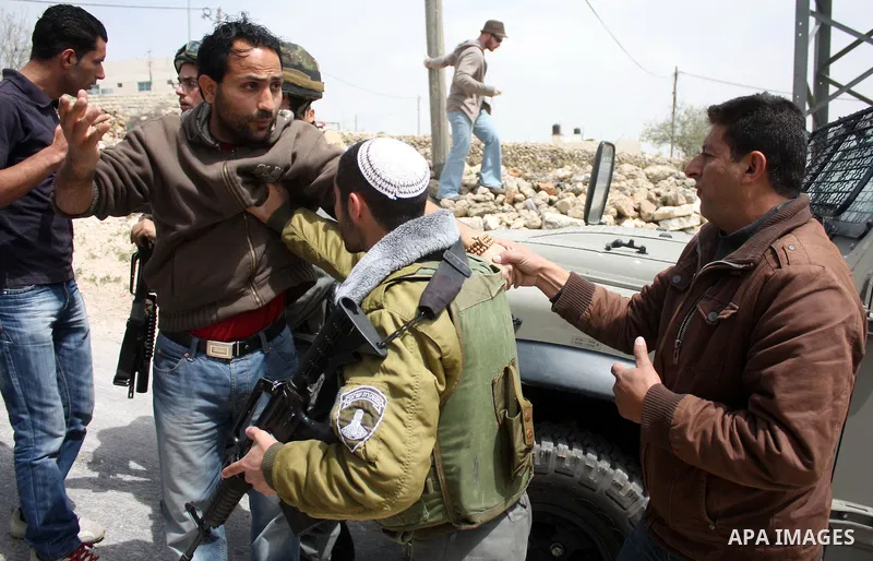 Protesters argue with an Israeli soldier during a demonstration against Israel's controversial separation barrier in the West Bank village of Maasarah, near the biblical town of Bethlehem on April 08, 2011.Israel says th...