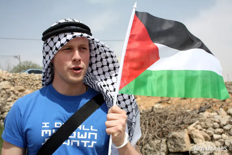 A protester holds a Palestinian flag during a demonstration against Israel's controversial separation barrier in the West Bank village of Maasarah, near the biblical town of Bethlehem on April 08, 2011.Israel says the ne...