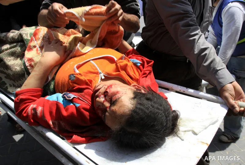 The body of 21-year-old Nidal Qudeih is carried into the mortuary of a hospital in the southern Gaza Strip city of Khan Yunis following an Israeli air strike on the Qarara region, northeast of Khan Yunis, on April 8, 201...