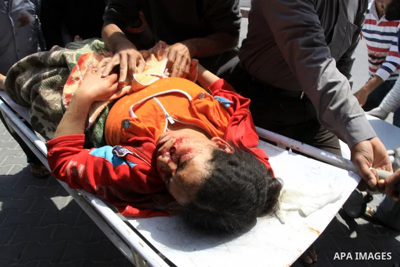 The body of 21-year-old Nidal Qudeih is carried into the mortuary of a hospital in the southern Gaza Strip city of Khan Yunis following an Israeli air strike on the Qarara region, northeast of Khan Yunis, on April 8, 201...
