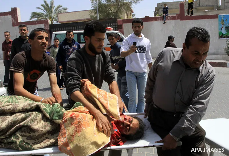 The body of 21-year-old Nidal Qudeih is carried into the mortuary of a hospital in the southern Gaza Strip city of Khan Yunis following an Israeli air strike on the Qarara region, northeast of Khan Yunis, on April 8, 201...