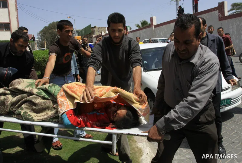 The body of 21-year-old Nidal Qudeih is carried into the mortuary of a hospital in the southern Gaza Strip city of Khan Yunis following an Israeli air strike on the Qarara region, northeast of Khan Yunis, on April 8, 201...