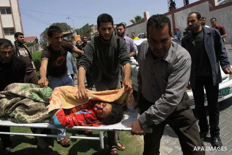 The body of 21-year-old Nidal Qudeih is carried into the mortuary of a hospital in the southern Gaza Strip city of Khan Yunis following an Israeli air strike on the Qarara region, northeast of Khan Yunis, on April 8, 201...