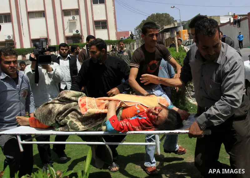 The body of 21-year-old Nidal Qudeih is carried into the mortuary of a hospital in the southern Gaza Strip city of Khan Yunis following an Israeli air strike on the Qarara region, northeast of Khan Yunis, on April 8, 201...