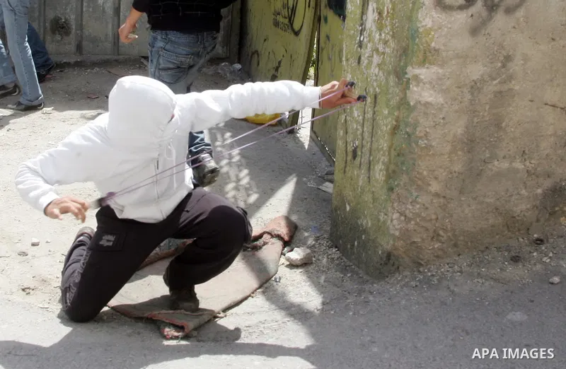 Palestinian youths hurl stones towards Israeli border police during clashes in the mostly Arab neighborhood of Silwan in East Jerusalem April 08, 2011. Photo by Mahfouz Abu Turk .