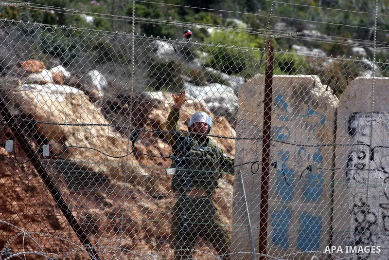 An Israeli soldier hurls tear gas canister towards Palestinian youths during the weekly demonstration against Israel's separation barrier in the West Bank village of Nilin, near Ramallah, Friday, April 8, 2011. Israel sa...