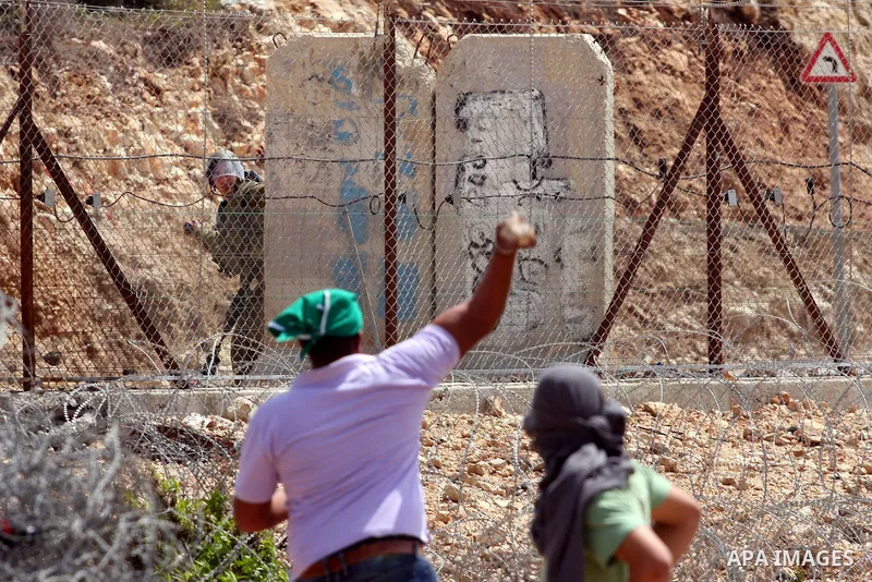 A Palestinian protestor hurls stones at Israeli soldiers during the weekly demonstration against Israel's separation barrier in the West Bank village of Nilin, near Ramallah, Friday, April 8, 2011. Israel says the barrie...