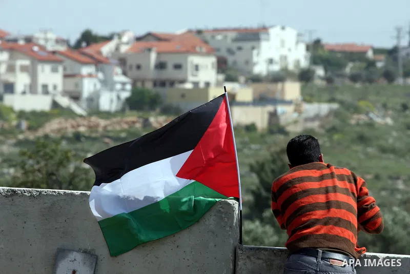 A Palestinian youth climbs the Israeli separation barrier during the weekly demonstration against Israel's separation barrier in the West Bank village of Nilin, near Ramallah, Friday, April 8, 2011. Israel says the barri...