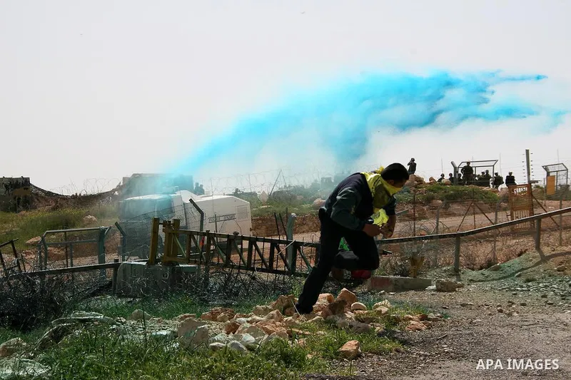 Palestinian protestors run for cover colored water during the weekly demonstration against Israel's separation barrier in the West Bank village of Bilin, near Ramallah, Friday, April 8, 2011. Israel says the barrier is n...
