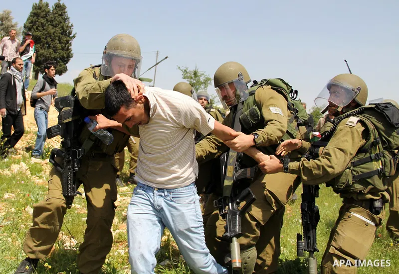 Israeli soldiers detain a protester during the weekly demonstration against Israel's separation barrier in the West Bank village of Nabi Saleh, near Ramallah, Friday, April 8, 2011. Israel says the barrier is necessary f...