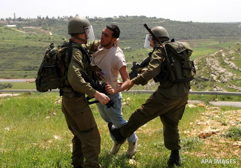 Israeli soldiers detain a protester during the weekly demonstration against Israel's separation barrier in the West Bank village of Nabi Saleh, near Ramallah, Friday, April 8, 2011. Israel says the barrier is necessary f...