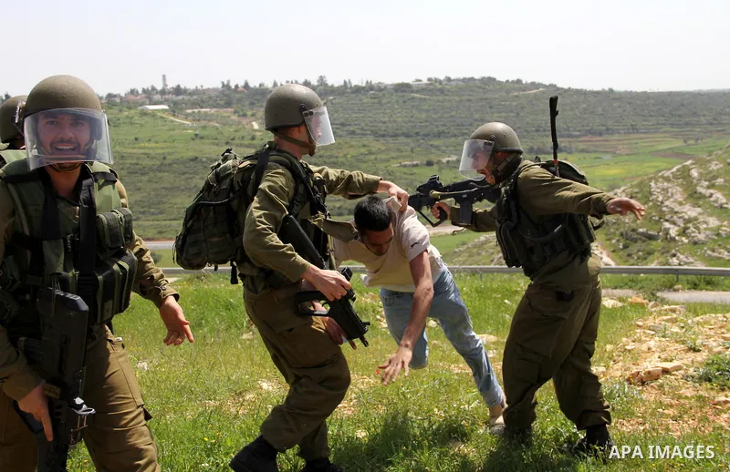 Israeli soldiers detain a protester during the weekly demonstration against Israel's separation barrier in the West Bank village of Nabi Saleh, near Ramallah, Friday, April 8, 2011. Israel says the barrier is necessary f...