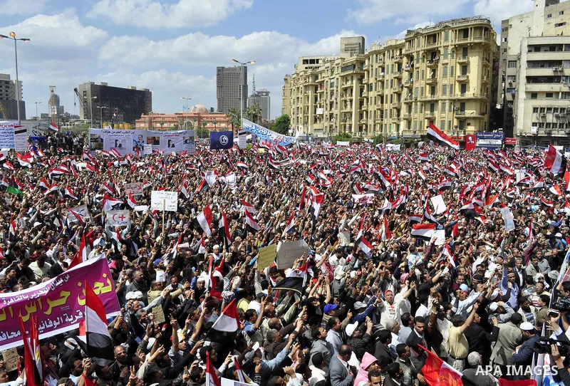 Egyptians hold flags and shout slogans as tens of thousands gathered for a demonstration at Cairo's Tahrir Square on April 8, 2011, two months after president Hosni Mubarak was ousted, to demand that former regime offici...