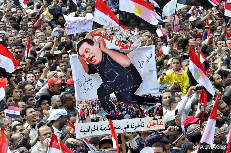 Egyptians hold flags and shout slogans as tens of thousands gathered for a demonstration at Cairo's Tahrir Square on April 8, 2011, two months after president Hosni Mubarak was ousted, to demand that former regime offici...
