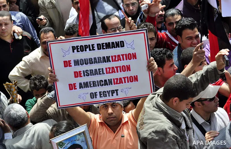 Egyptians hold flags and shout slogans as tens of thousands gathered for a demonstration at Cairo's Tahrir Square on April 8, 2011, two months after president Hosni Mubarak was ousted, to demand that former regime offici...