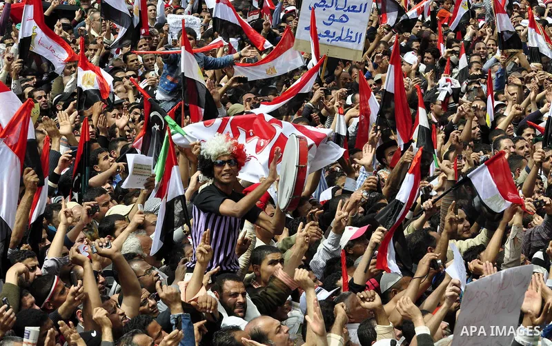 Egyptians hold flags and shout slogans as tens of thousands gathered for a demonstration at Cairo's Tahrir Square on April 8, 2011, two months after president Hosni Mubarak was ousted, to demand that former regime offici...