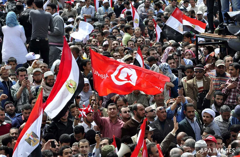 Egyptians hold flags and shout slogans as tens of thousands gathered for a demonstration at Cairo's Tahrir Square on April 8, 2011, two months after president Hosni Mubarak was ousted, to demand that former regime offici...