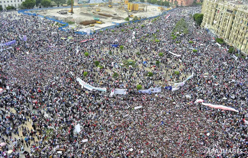 Egyptians hold flags and shout slogans as tens of thousands gathered for a demonstration at Cairo's Tahrir Square on April 8, 2011, two months after president Hosni Mubarak was ousted, to demand that former regime offici...