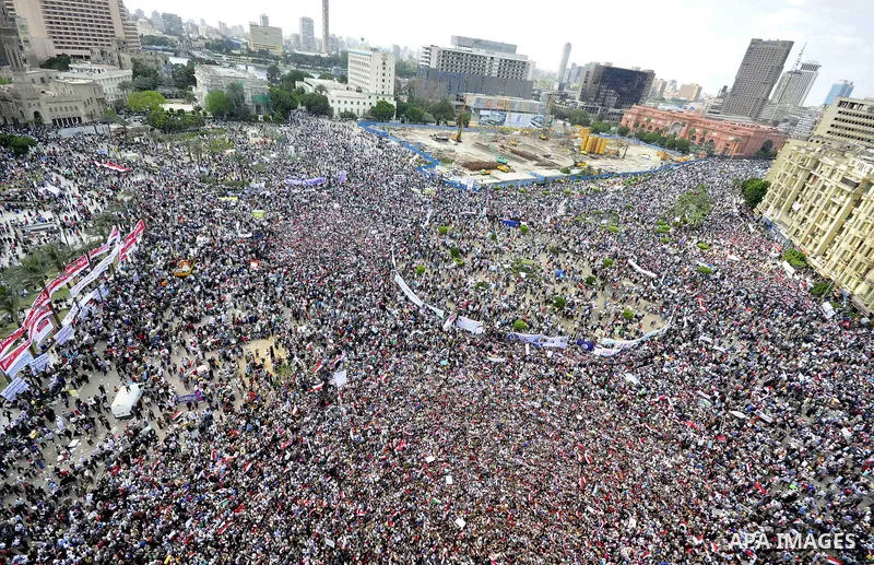 Egyptians hold flags and shout slogans as tens of thousands gathered for a demonstration at Cairo's Tahrir Square on April 8, 2011, two months after president Hosni Mubarak was ousted, to demand that former regime offici...