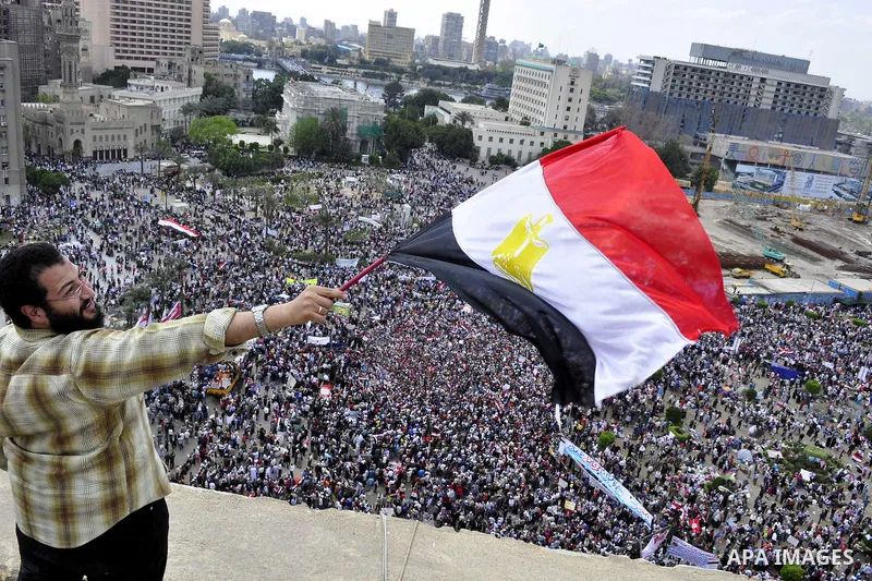 Egyptians hold flags and shout slogans as tens of thousands gathered for a demonstration at Cairo's Tahrir Square on April 8, 2011, two months after president Hosni Mubarak was ousted, to demand that former regime offici...