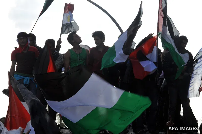 Egyptian protesters wave Palestinian flags as they gather outside the Israeli embassy in Cairo on April 8, 2011 to protest against the Israeli strikes on the neighbouring Gaza Strip, which have killed 16 people in the pa...