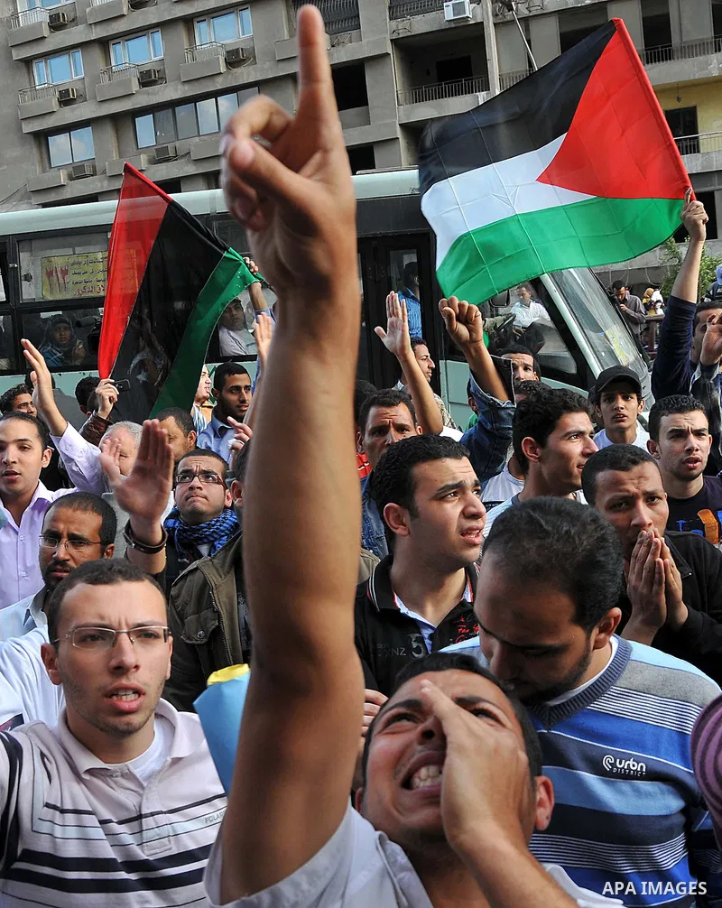 Egyptian protesters wave Palestinian flags as they gather outside the Israeli embassy in Cairo on April 8, 2011 to protest against the Israeli strikes on the neighbouring Gaza Strip, which have killed 16 people in the pa...
