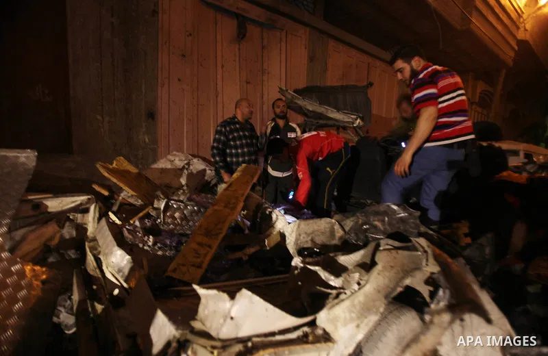 Palestinians surround a destroyed car after an Israeli airstrike in Gaza City, on April 9, 2011. Israeli aircraft and ground forces struck Gaza on Friday, killing four Hamas militants and five civilians in a surge of fig...