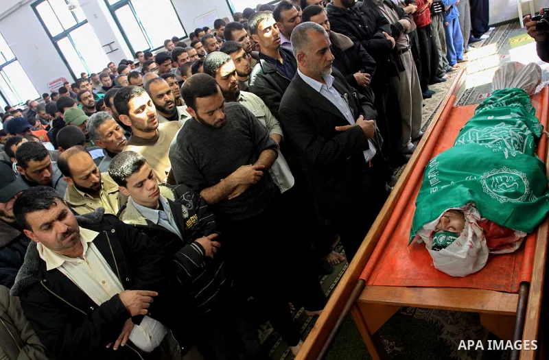 Palestinians pray next to the body of Hamas militant Ahmed Zaitonia during his funeral in Gaza City, April 9, 2011. as the Israeli army pounded the Gaza Strip, killing at least 12 people as militants fired dozens of mort...