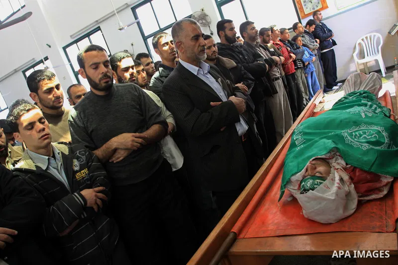 Palestinians pray next to the body of Hamas militant Ahmed Zaitonia during his funeral in Gaza City, April 9, 2011. as the Israeli army pounded the Gaza Strip, killing at least 12 people as militants fired dozens of mort...