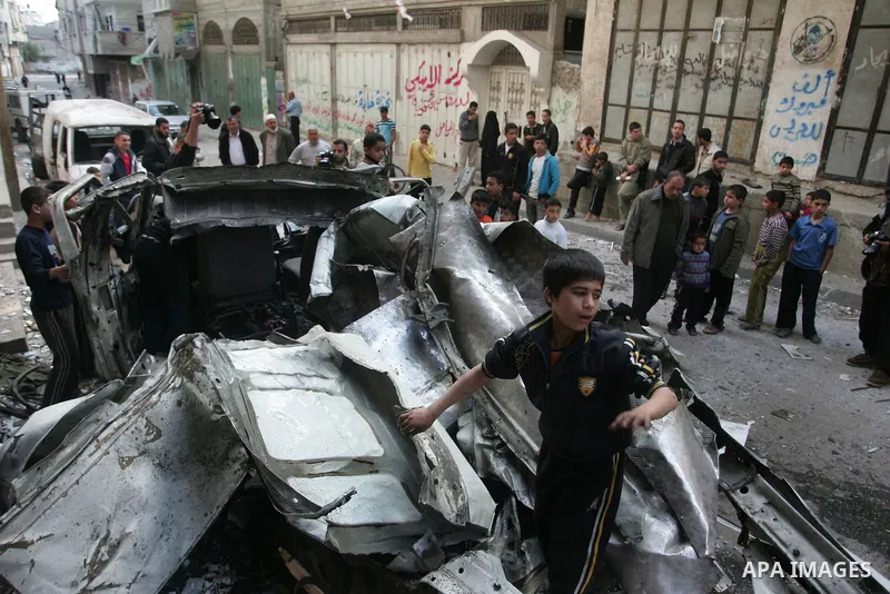 Palestinians inspect the damage to a vehicle after an Israeli air strike in Gaza City April 9, 2011. Israel killed four Palestinian militants and wounded half a dozen others as it pursued air raids in Gaza for a third da...