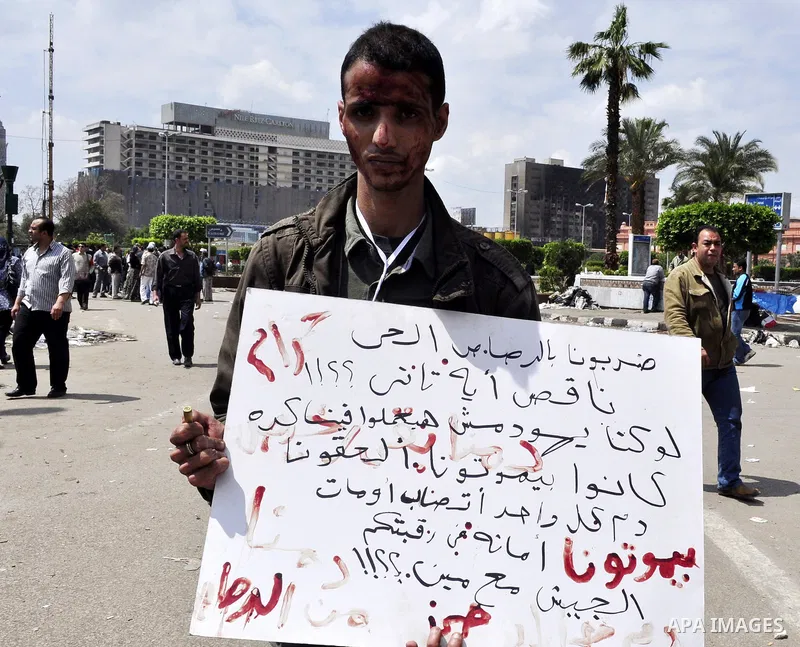 Protesters chant slogans as they march following an attack by security forces in Tahrir Square, in Cairo, Egypt, Saturday, April 9, 2011. Demonstrators burned cars and barricaded themselves with barbed wire inside a cent...