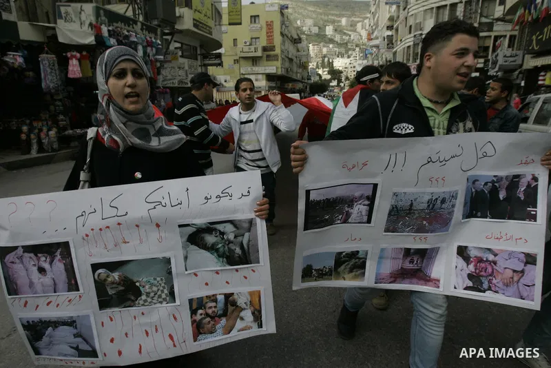 Palestinians hold placards during a rally in solidarity with Gazans people and against the Israeli military operation, in the West Bank city of Nablus on April 9,2011. About 17 Palestinians including 8 civilians were kil...