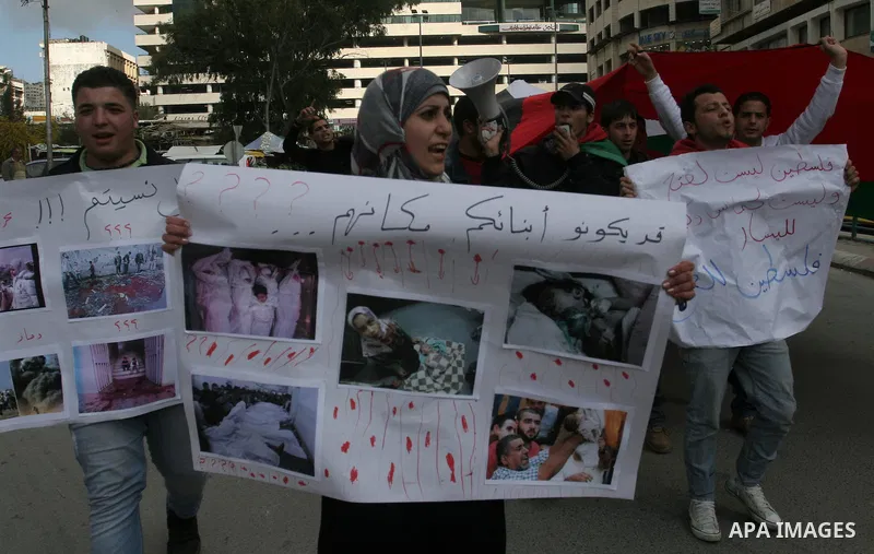 Palestinians hold placards during a rally in solidarity with Gazans people and against the Israeli military operation, in the West Bank city of Nablus on April 9,2011. About 17 Palestinians including 8 civilians were kil...