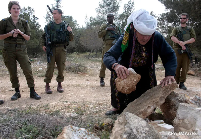 A Palestinian woman quarrels with Israeli soldiers during a protest rally against Jewish settlers in the West Bank village of Yatta, south of Hebron, on April 09,2011.Photo by Najeh Hahlamoun