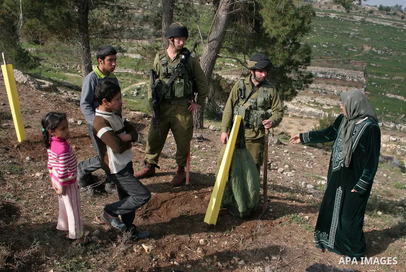 A Palestinian demonstrator argues with an Israeli soldier during a protest against Israel's controversial separation barrier organized by Palestinian and foreign peace activists in the West Bank village of Safa, near Heb...