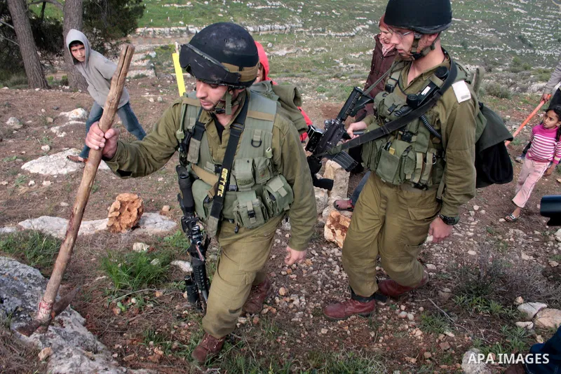 A Palestinian demonstrator argues with an Israeli soldier during a protest against Israel's controversial separation barrier organized by Palestinian and foreign peace activists in the West Bank village of Safa, near Heb...