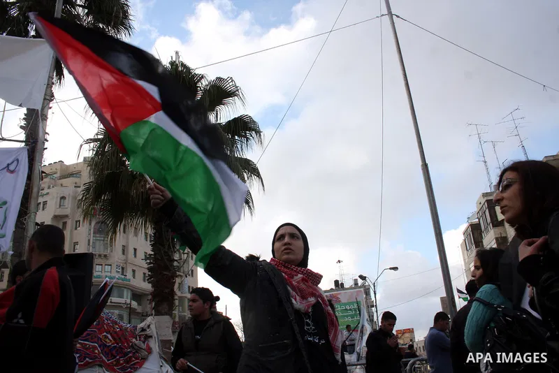 Palestinians hold national flags during a rally in solidarity with Gazans people and against the Israeli military operation, in the West Bank city of Ramallah on April 9,2011. About 18 Palestinians including 8 civilians...