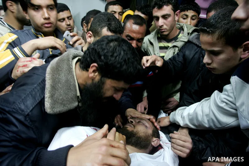Palestinian relatives gather around the body of Raed El-Bor at the morgue of AL-shifa hospital in gaza city, April 9, 2011.The Israeli army pounded the Gaza Strip, killing at least 12 people while militants fired dozens...