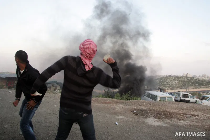 Palestinian youths hurl stones towards Israeli soldiers during clashes in the most Arab neighbourhood of Issawiah in Jerusalem on April 9,2011. Photo by Mahfouz Abu Turk