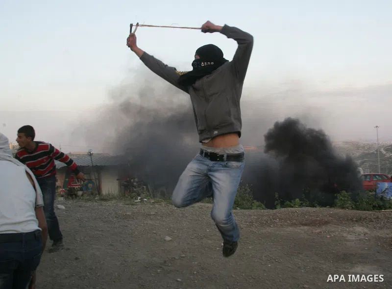 Palestinian youths hurl stones towards Israeli soldiers during clashes in the most Arab neighbourhood of Issawiah in Jerusalem on April 9,2011. Photo by Mahfouz Abu Turk