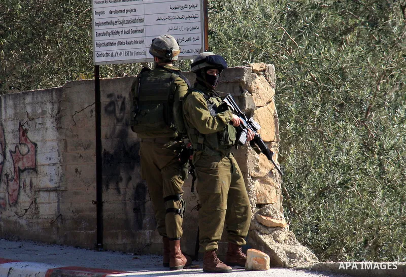 Israeli soldiers stand guard during a search operation in the village of Awarta, in the Israeli occupied northern West Bank on April 10, 2011, a day after Jewish settlers went on the rampage in two nearby Palestinian vil...