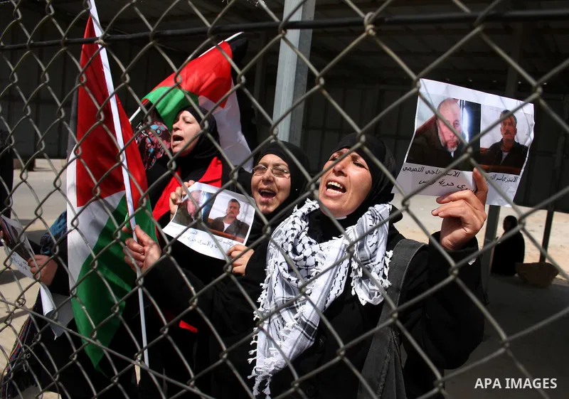 Palestinians stand at the gate of the Israeli controlled Ofer jail during a protest calling for the release of prisoners in the West Bank city of Ramallah on April 10,2011. Photo by Issam Rimawi
