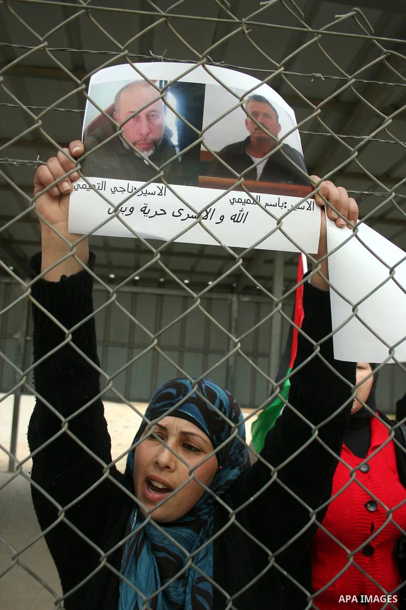 Palestinians stand at the gate of the Israeli controlled Ofer jail during a protest calling for the release of prisoners in the West Bank city of Ramallah on April 10,2011. Photo by Issam Rimawi