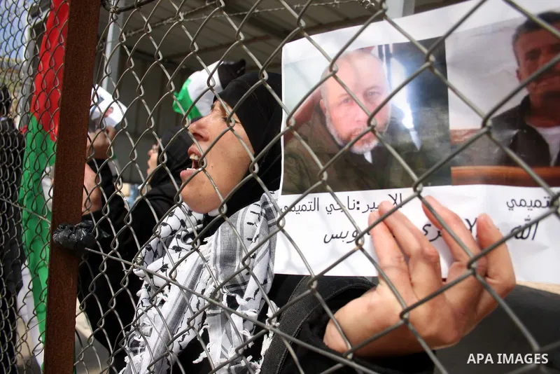 Palestinians stand at the gate of the Israeli controlled Ofer jail during a protest calling for the release of prisoners in the West Bank city of Ramallah on April 10,2011. Photo by Issam Rimawi