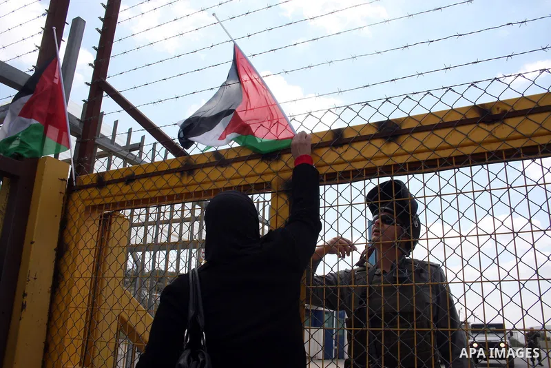 Palestinians stand at the gate of the Israeli controlled Ofer jail during a protest calling for the release of prisoners in the West Bank city of Ramallah on April 10,2011. Photo by Issam Rimawi